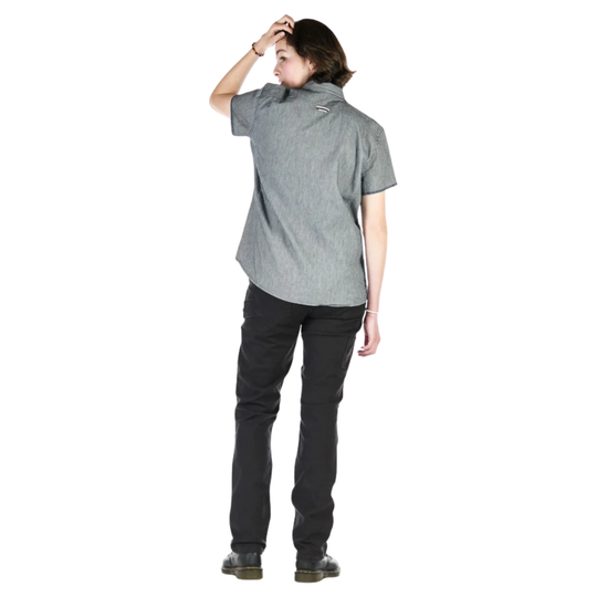 Person wearing a gray shirt and dark pants on a white background