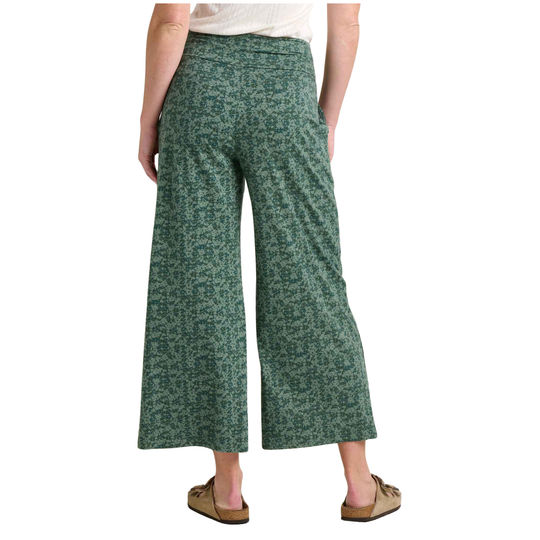Green patterned wide-leg pants worn by a person on a white background
