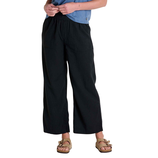 Person wearing black wide-leg pants on a white background