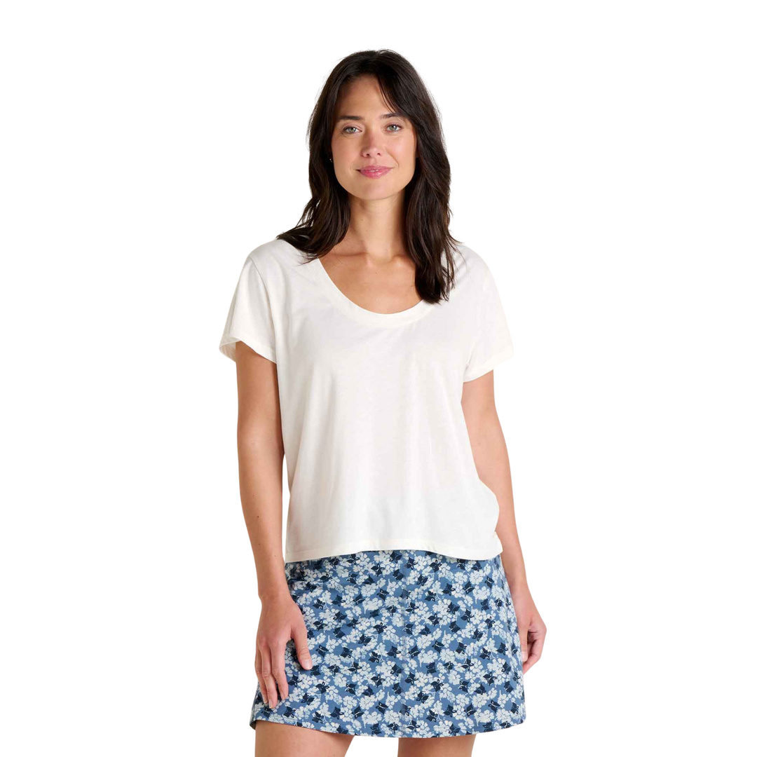 Woman wearing a white top and blue floral skirt on a white background