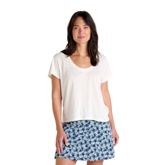 Woman wearing a white top and blue floral skirt on a white background