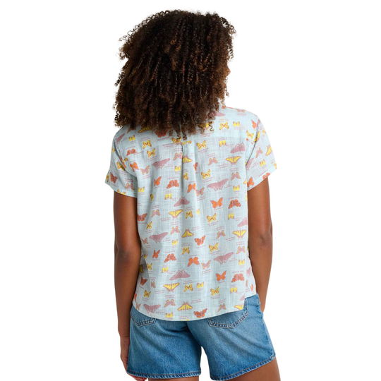 Person wearing a light blue t-shirt with colorful butterfly pattern on a white background
