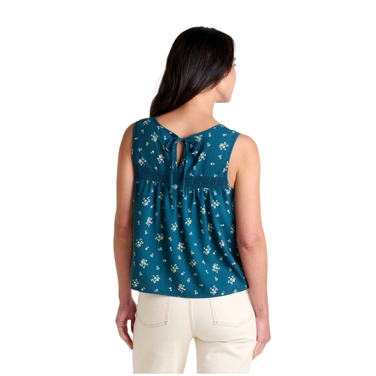 Woman wearing a blue floral sleeveless top with a white background