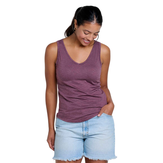 Woman wearing a purple tank top and light blue shorts on a white background