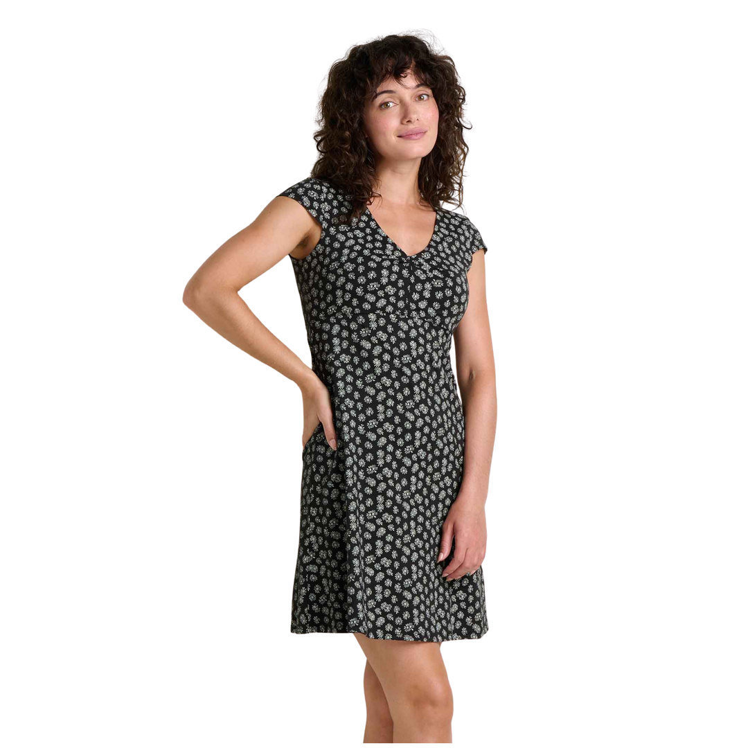 Woman wearing a black dress with white floral pattern on a white background
