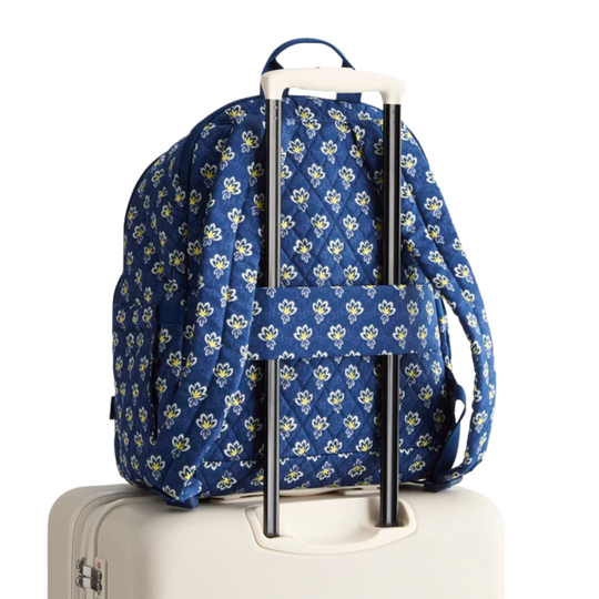 Blue floral-patterned backpack on white luggage on a white background