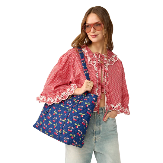 Blue quilted bag with cherry pattern on female model