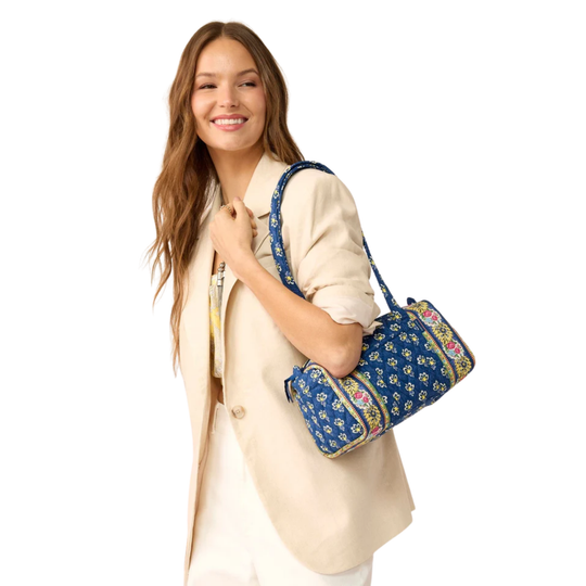 Woman holding a blue floral-patterned bag on a white background