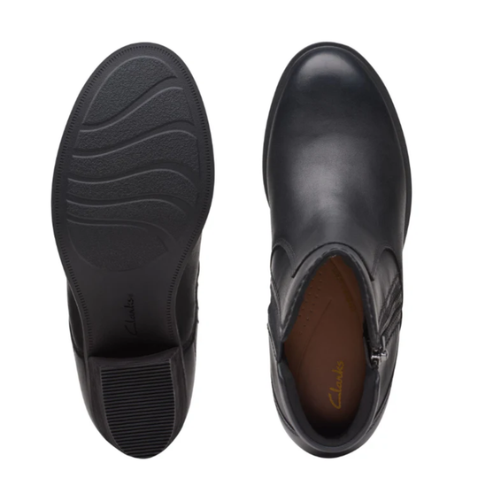 Black leather ankle boot with sole showing on a white background