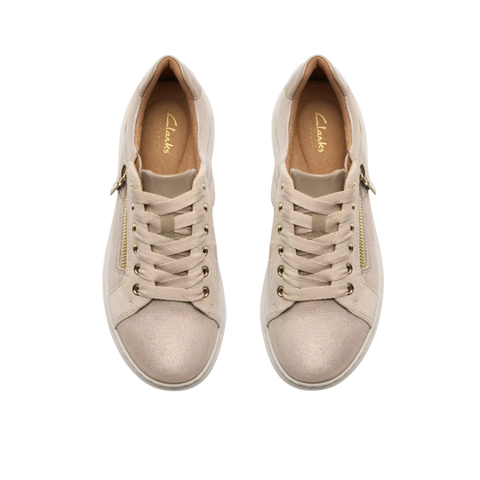 Pair of beige sneakers with gold accents on a white background