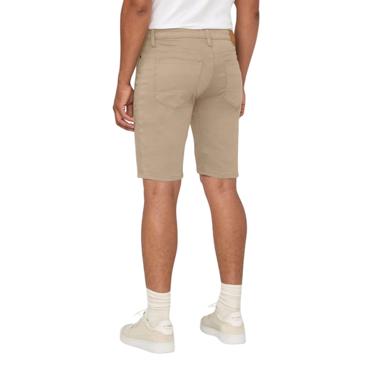 Beige shorts worn by a person on a white background
