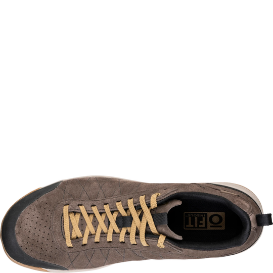 Brown sneaker with yellow laces on a white background