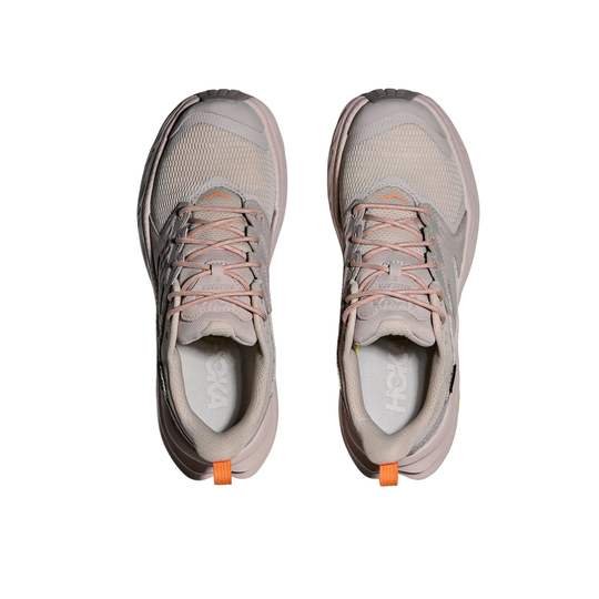 Pair of gray athletic shoes with orange accents on a white background