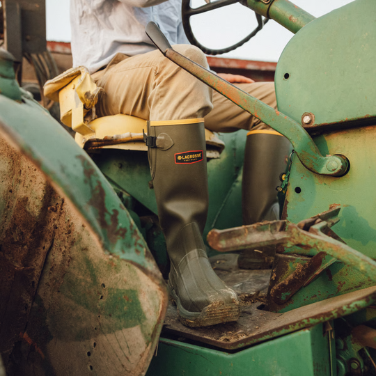 green hunting boots with model sitting on tractor
