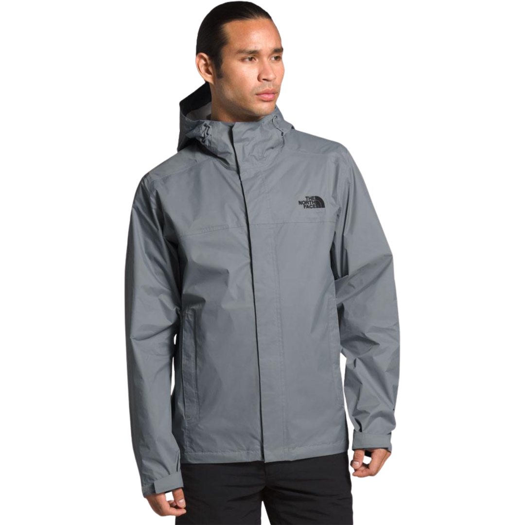 Person wearing a gray rain jacket with a brand logo on a white background