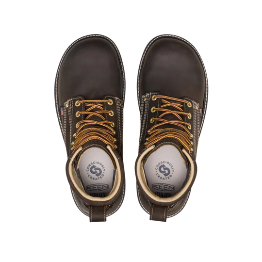 Pair of brown leather boots with orange laces on a white background