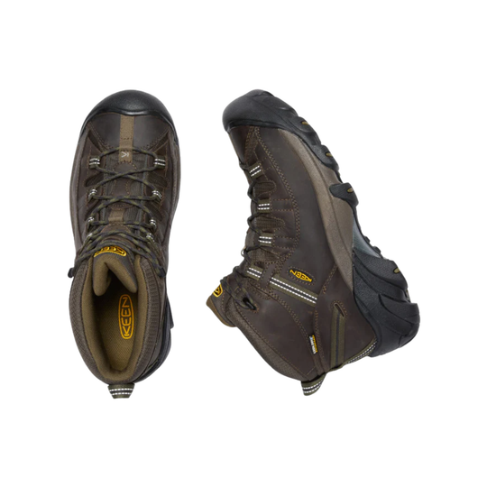 Brown mid-height hiking boots with black rubber toe caps, bungee laces, and KEEN logos