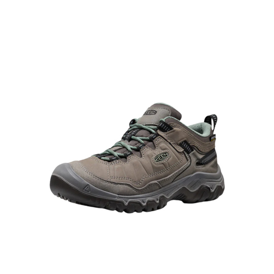 Brown hiking shoe with green laces on a white background