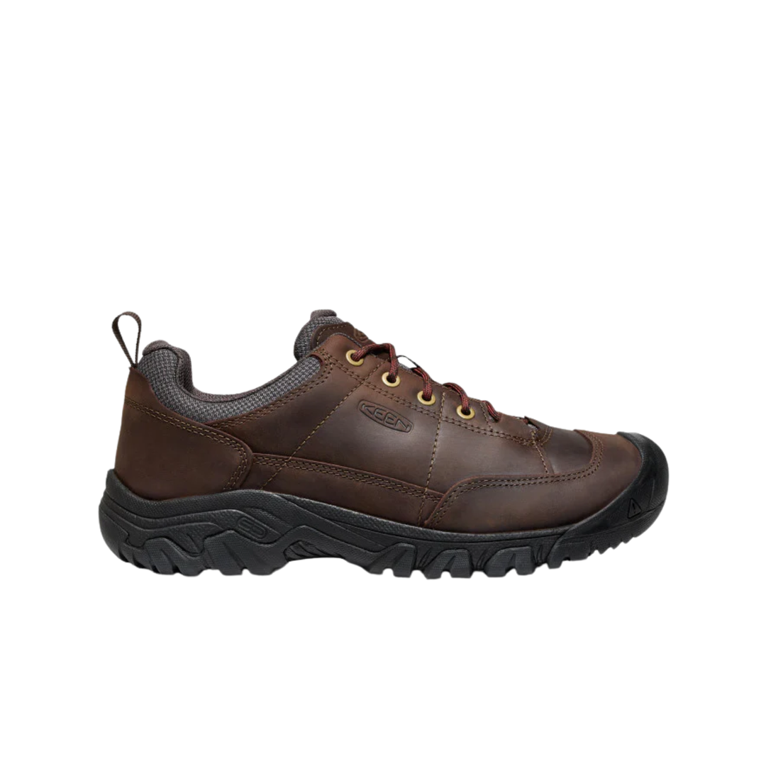 Brown leather shoe with black sole on a white background
