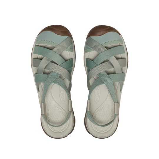 Light green sandals with brown sole on a white background