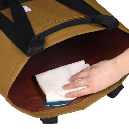 Brown bag with a hand holding a white cloth inside, on a white background
