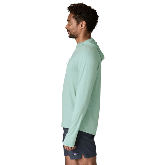 Man wearing a light green hoodie and dark shorts on a white background