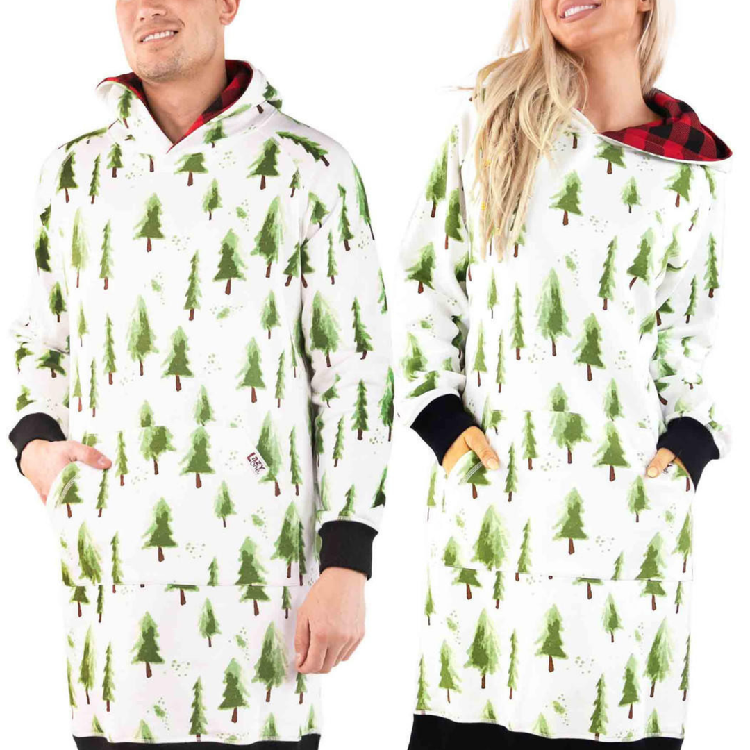 Two people wearing white hooded blankets with green tree patterns on a white background