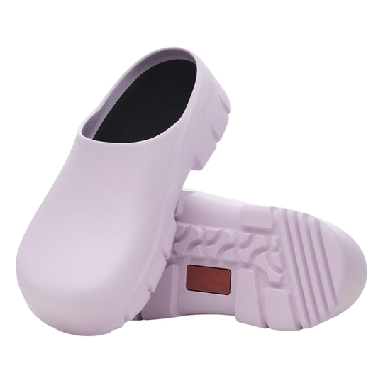Pair of light purple slip-on shoes with a brown label on a white background