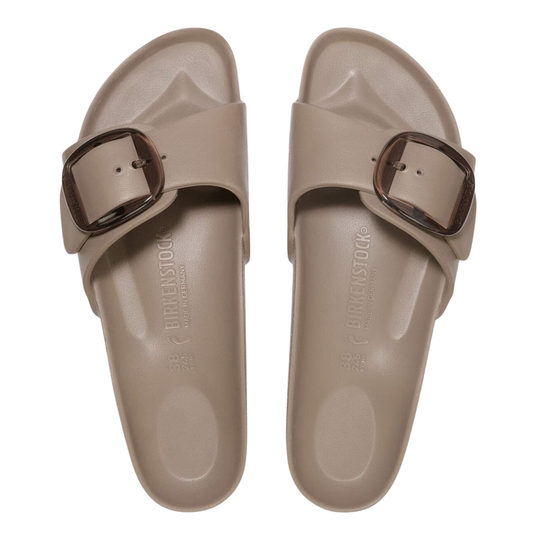 Pair of beige sandals with brown buckles on a white background