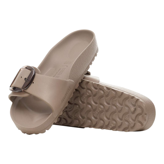 Pair of beige sandals with a buckle on a white background