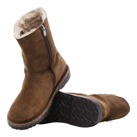 Brown suede boots with fur lining and zippers on a white background