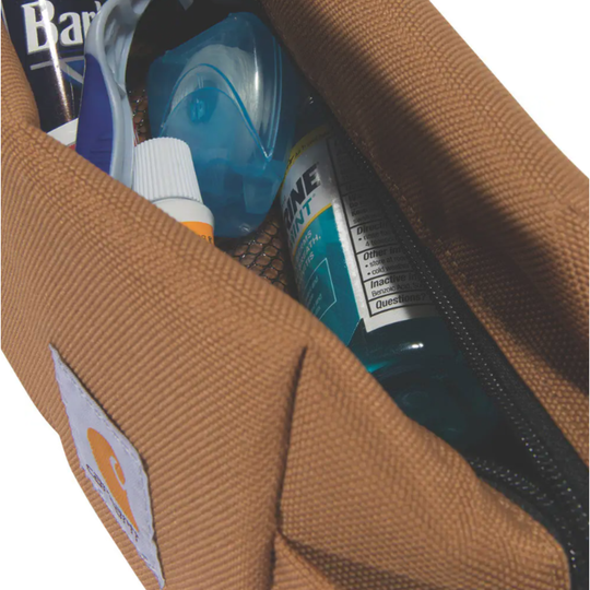 Brown toiletry bag with personal care items including a bottle of Bonine.