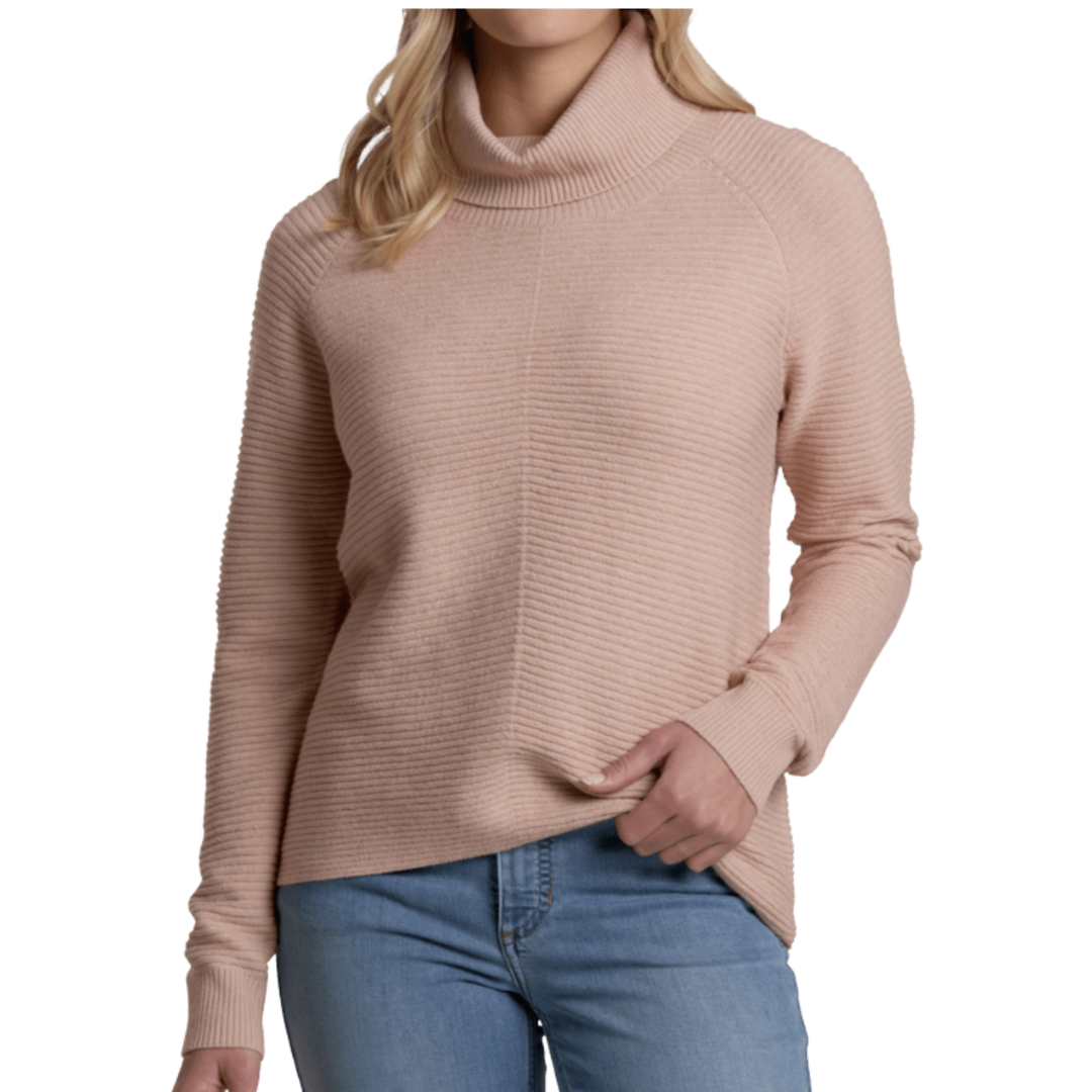Person wearing a beige turtleneck sweater and blue jeans on a white background