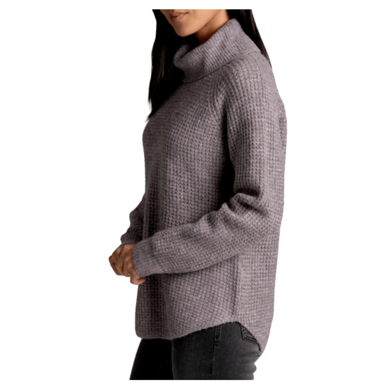 Person wearing a gray turtleneck sweater on a white background