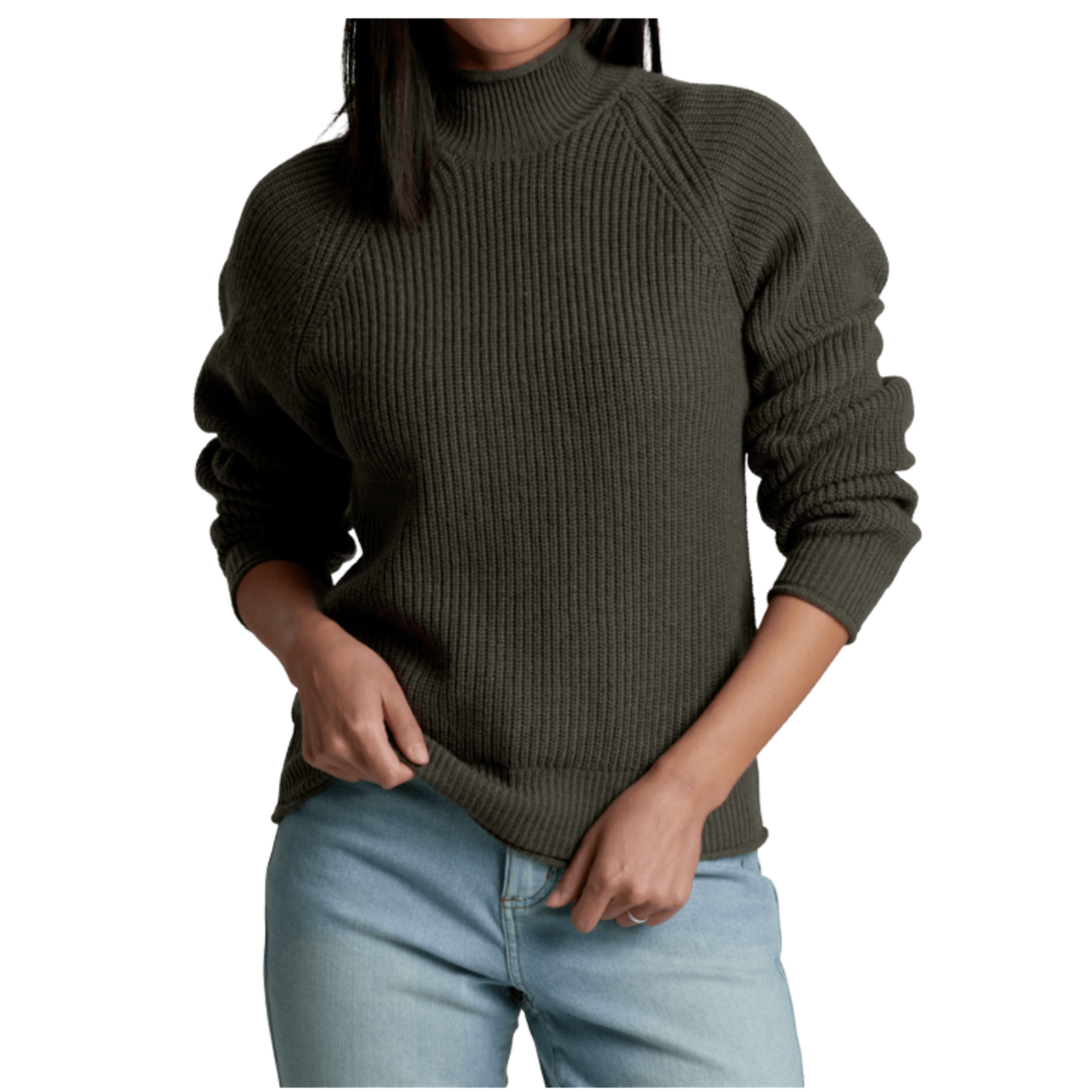 Person wearing a dark green ribbed sweater and light blue jeans on a white background