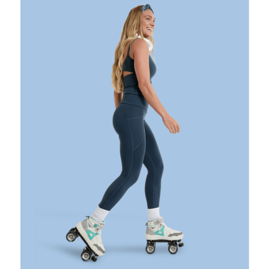 Woman roller skating on a solid blue background