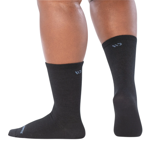 Black socks worn by a person on a white background