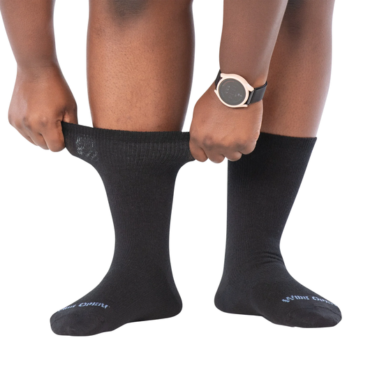 Person wearing black socks with a white background