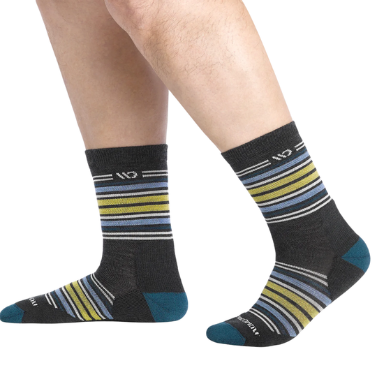 Striped socks with black, blue, and yellow pattern worn by a person on a white background