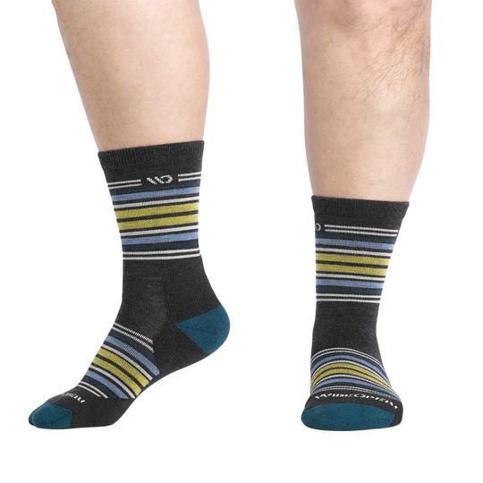 Black socks with colorful stripes worn by a person on a white background
