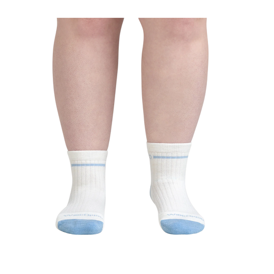 White socks with blue toes and cuffs worn by a person on a white background