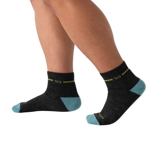 Black socks with teal accents worn by a person on a white background