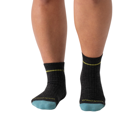 Black socks with blue toes worn by a person on a white background