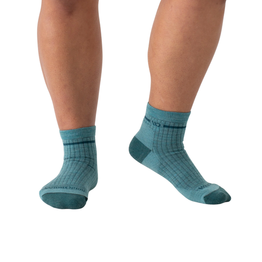 Teal socks worn by a person on a white background