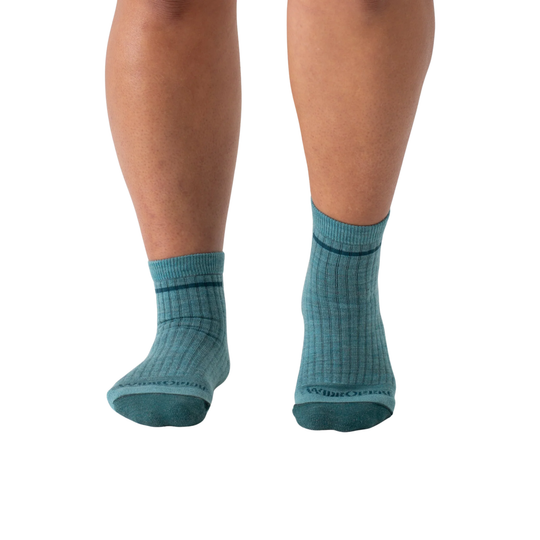 Teal socks worn by a person on a white background