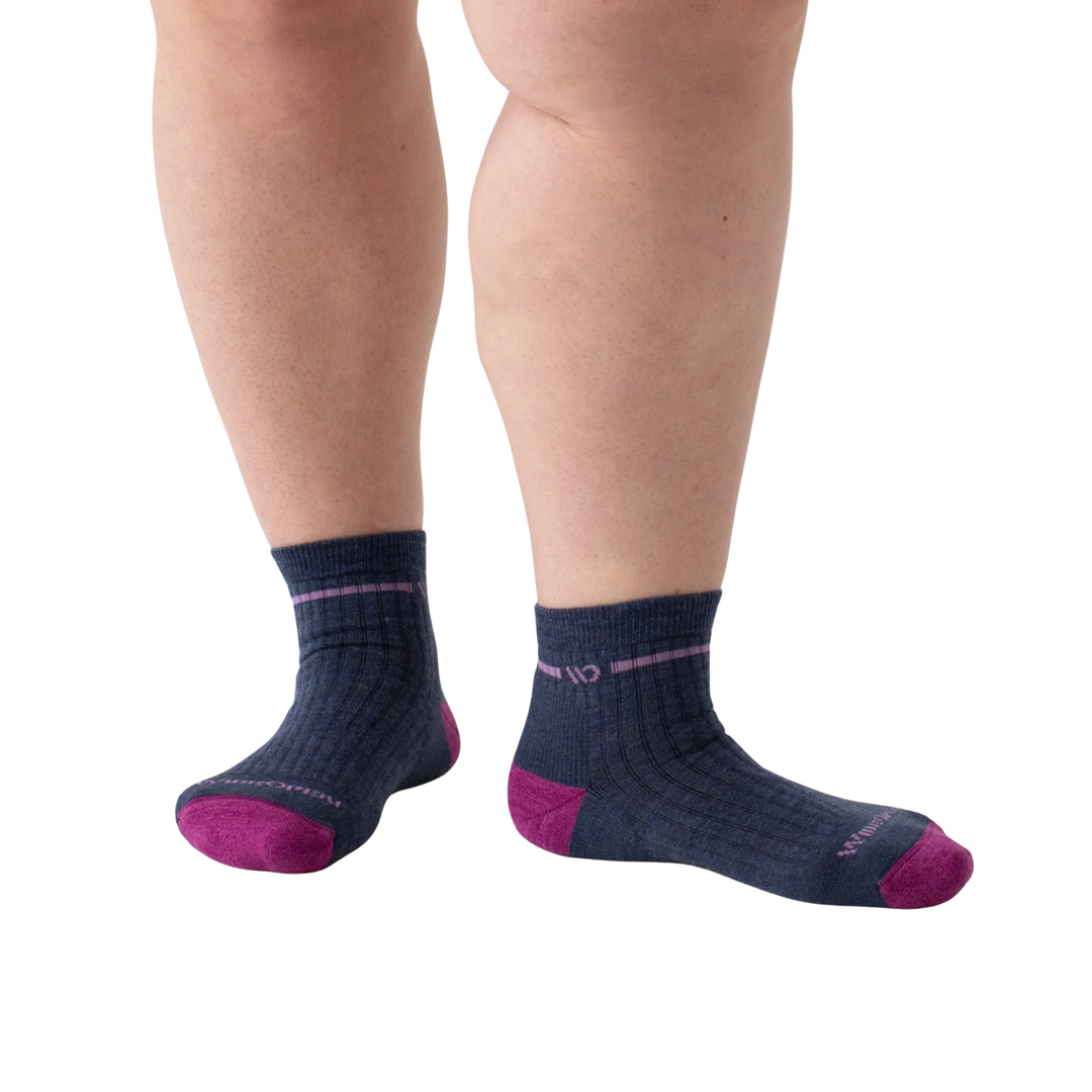 Navy socks with pink accents worn by a person on a white background