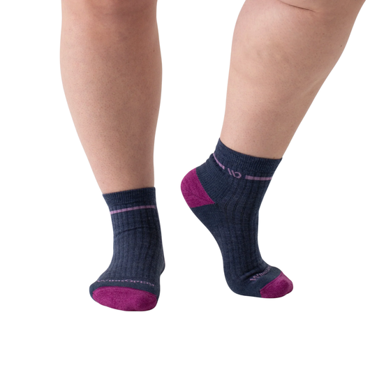 Navy socks with purple accents worn by a person on a white background