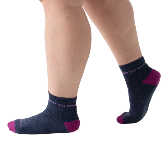 Navy socks with purple accents worn by a person on a white background