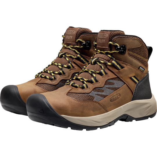 Pair of brown work boots with black soles on a white background