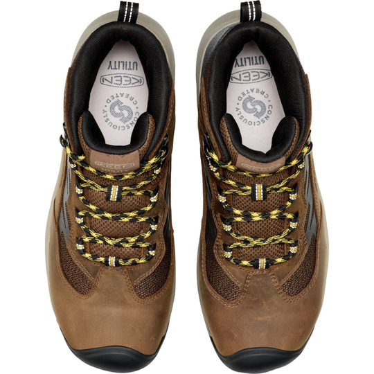 Pair of brown KEEN hiking shoes with yellow laces on a white background